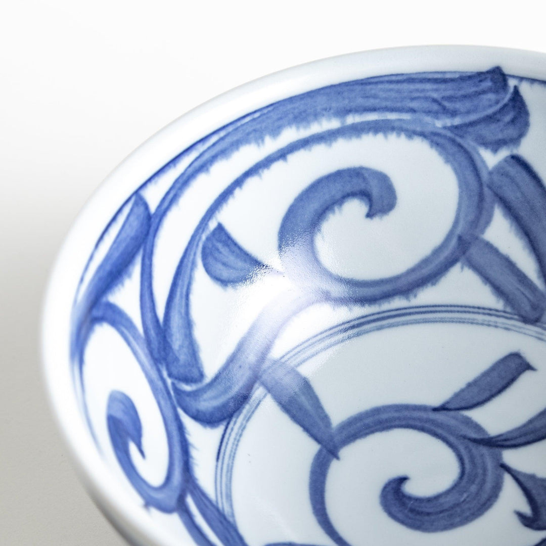 A bowl with a bold blue swirl pattern on a white background.