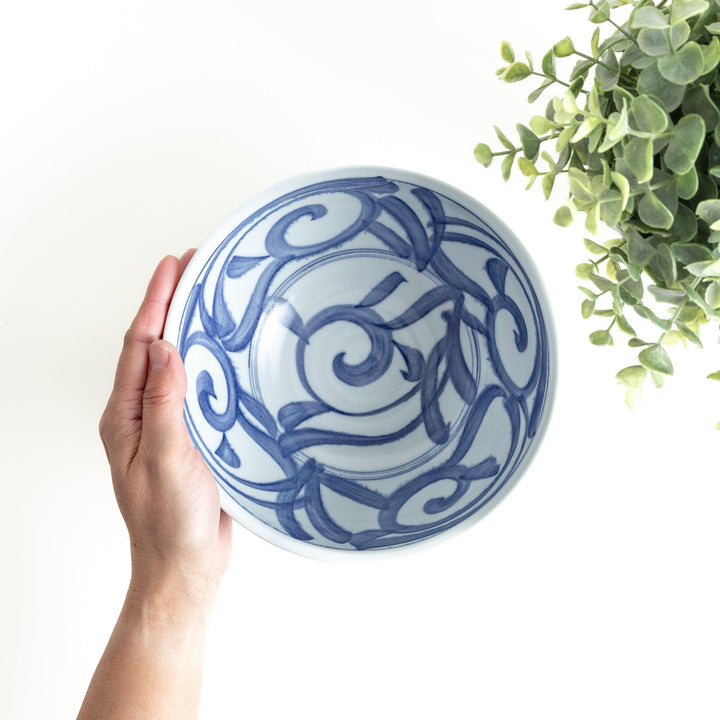 A bowl with a bold blue swirl pattern on a white background.