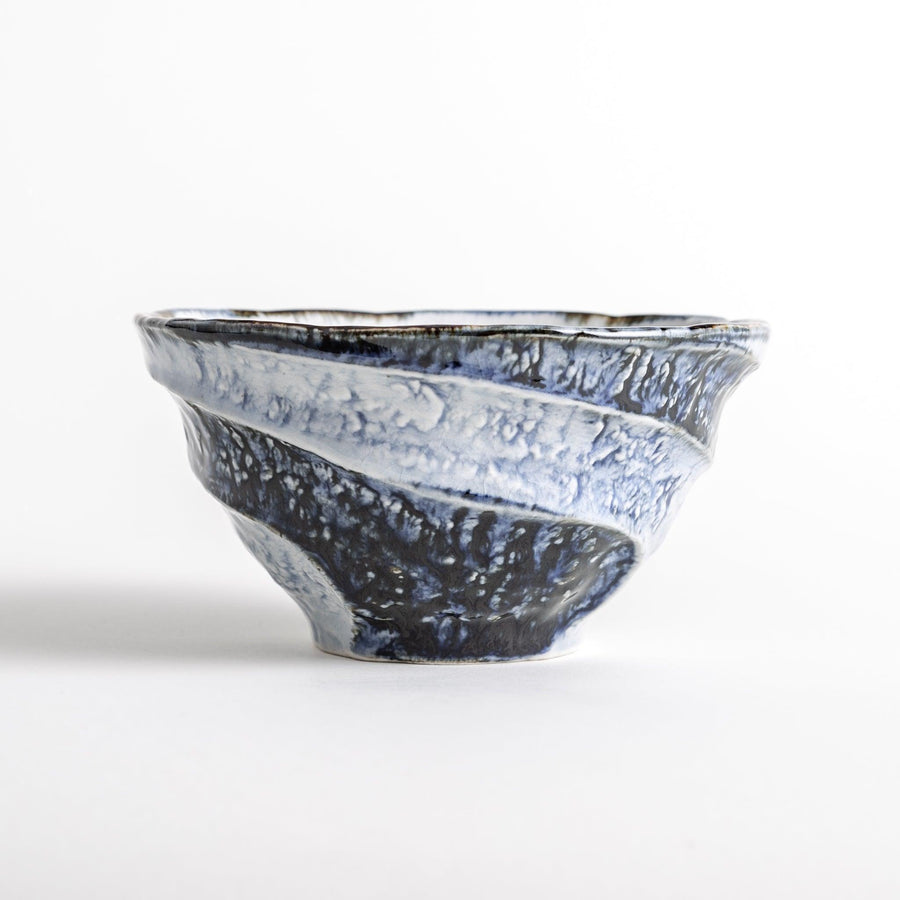 A bowl with a textured, uneven surface featuring blue and white glaze with an organic design.