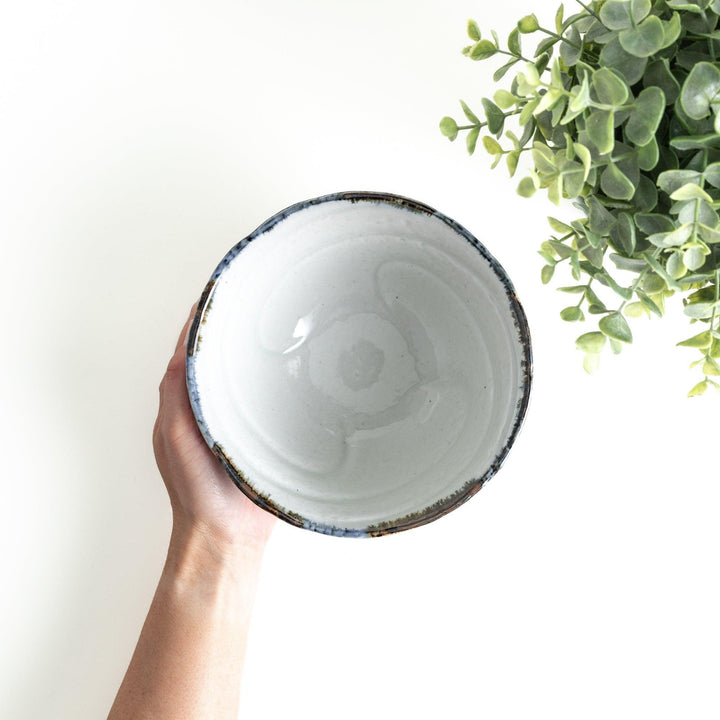 A bowl with a textured, uneven surface featuring blue and white glaze with an organic design.