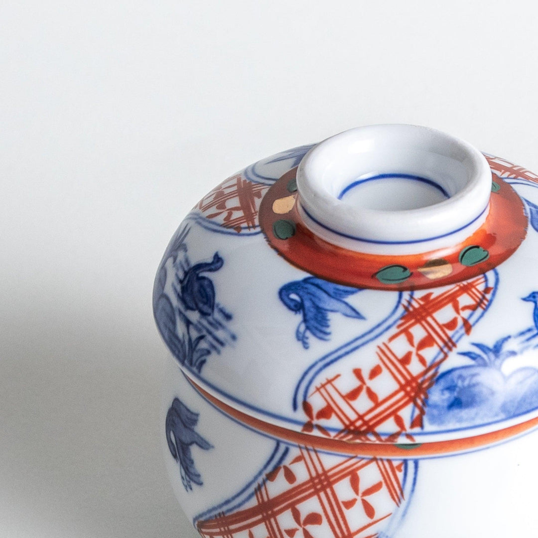 White ceramic cup with saucer, blue and orange floral design