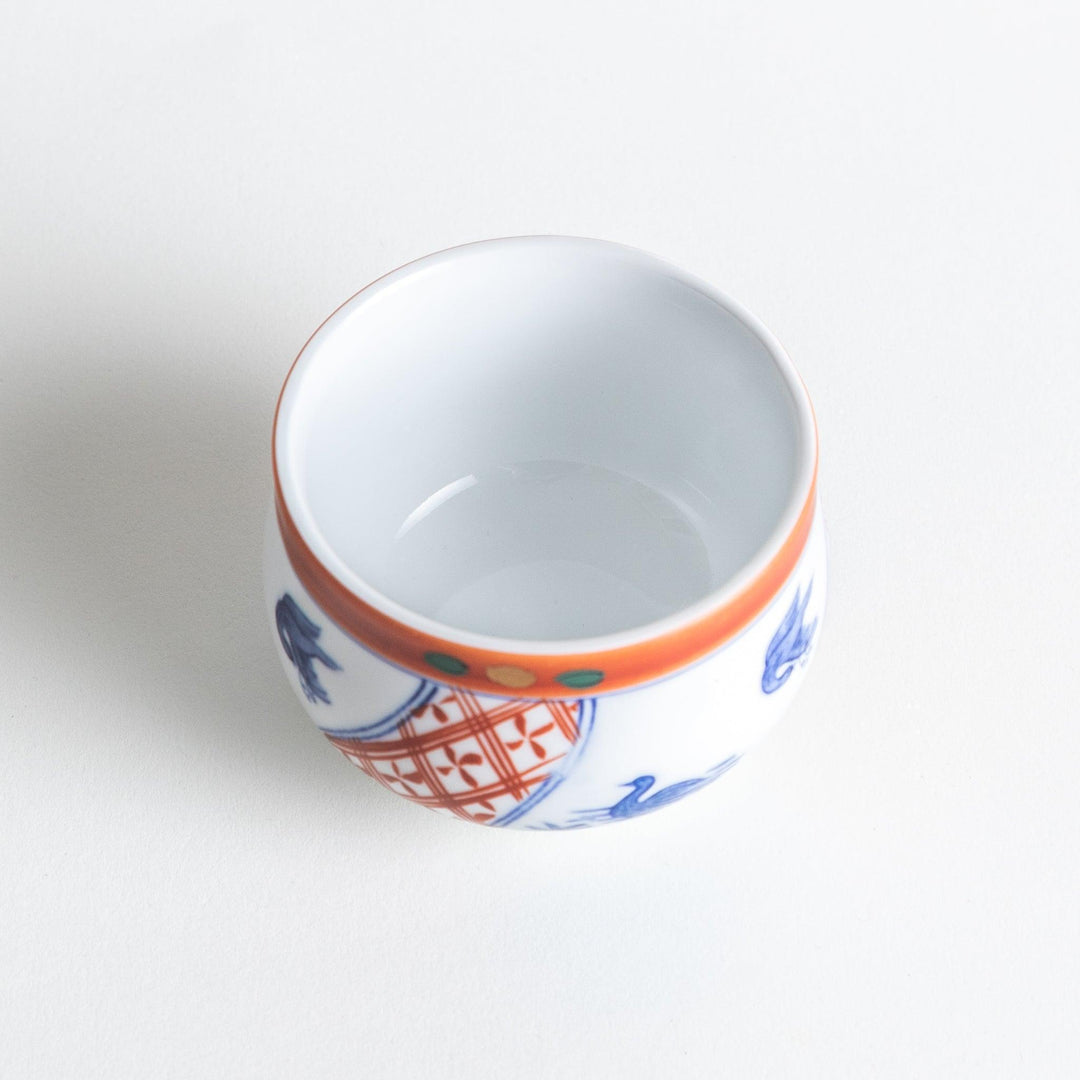 White ceramic cup with saucer, blue and orange floral design