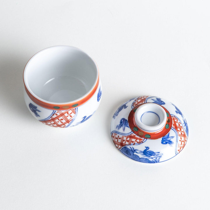 White ceramic cup with saucer, blue and orange floral design