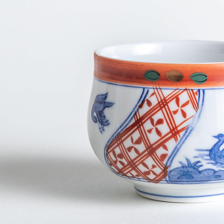 White ceramic cup with saucer, blue and orange floral design