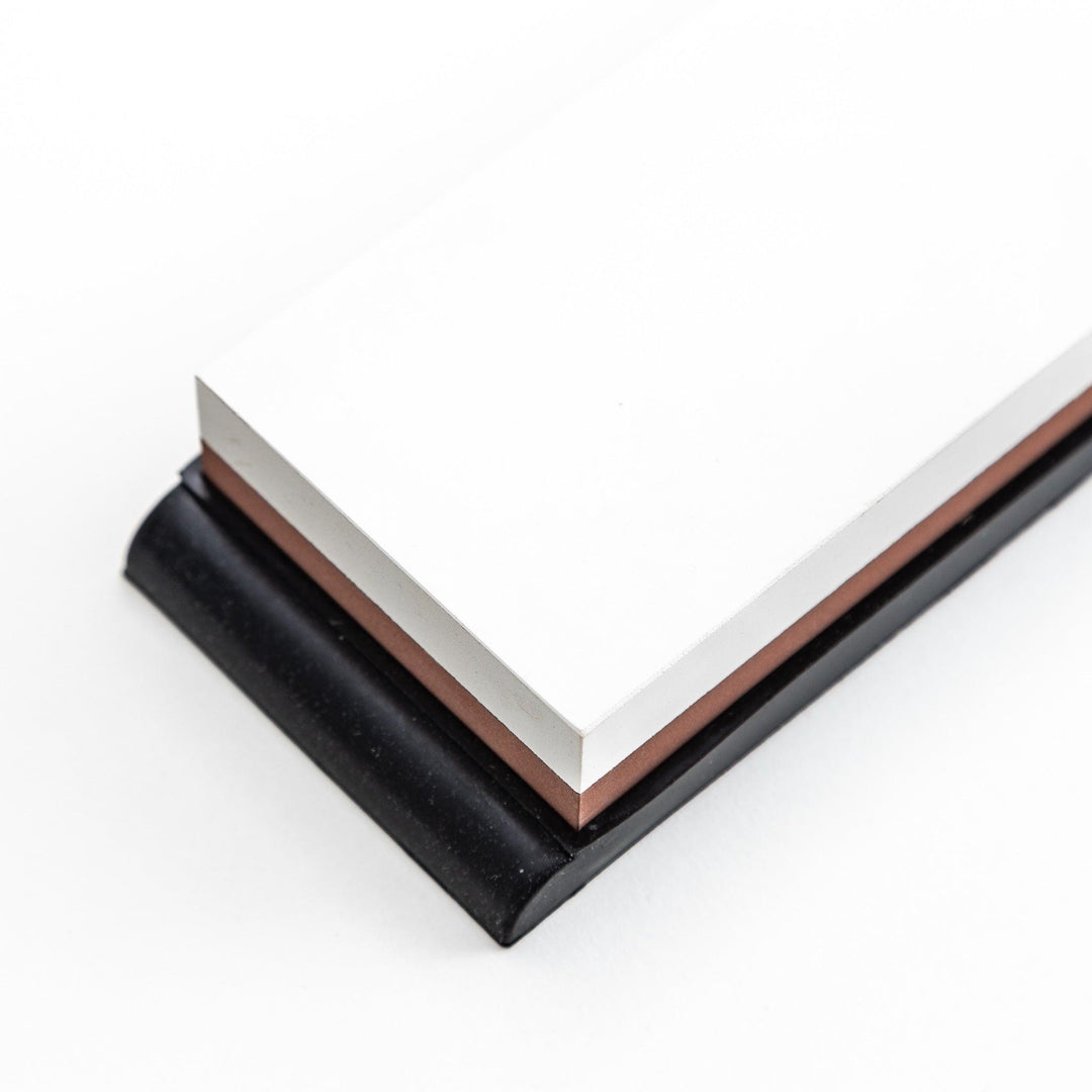 Rectangular sharpening stone with a brown surface and a black base, designed for honing knife blades.