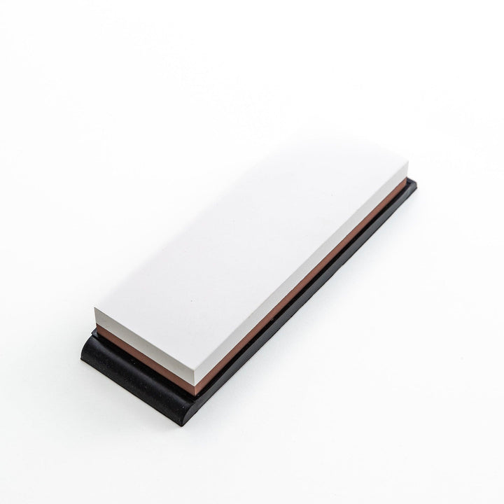 Rectangular sharpening stone with a brown surface and a black base, designed for honing knife blades.