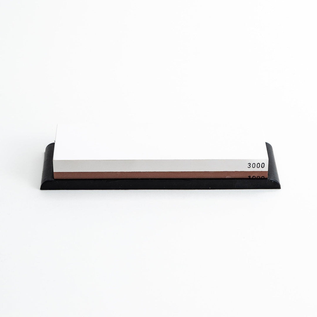 Rectangular sharpening stone with a brown surface and a black base, designed for honing knife blades.