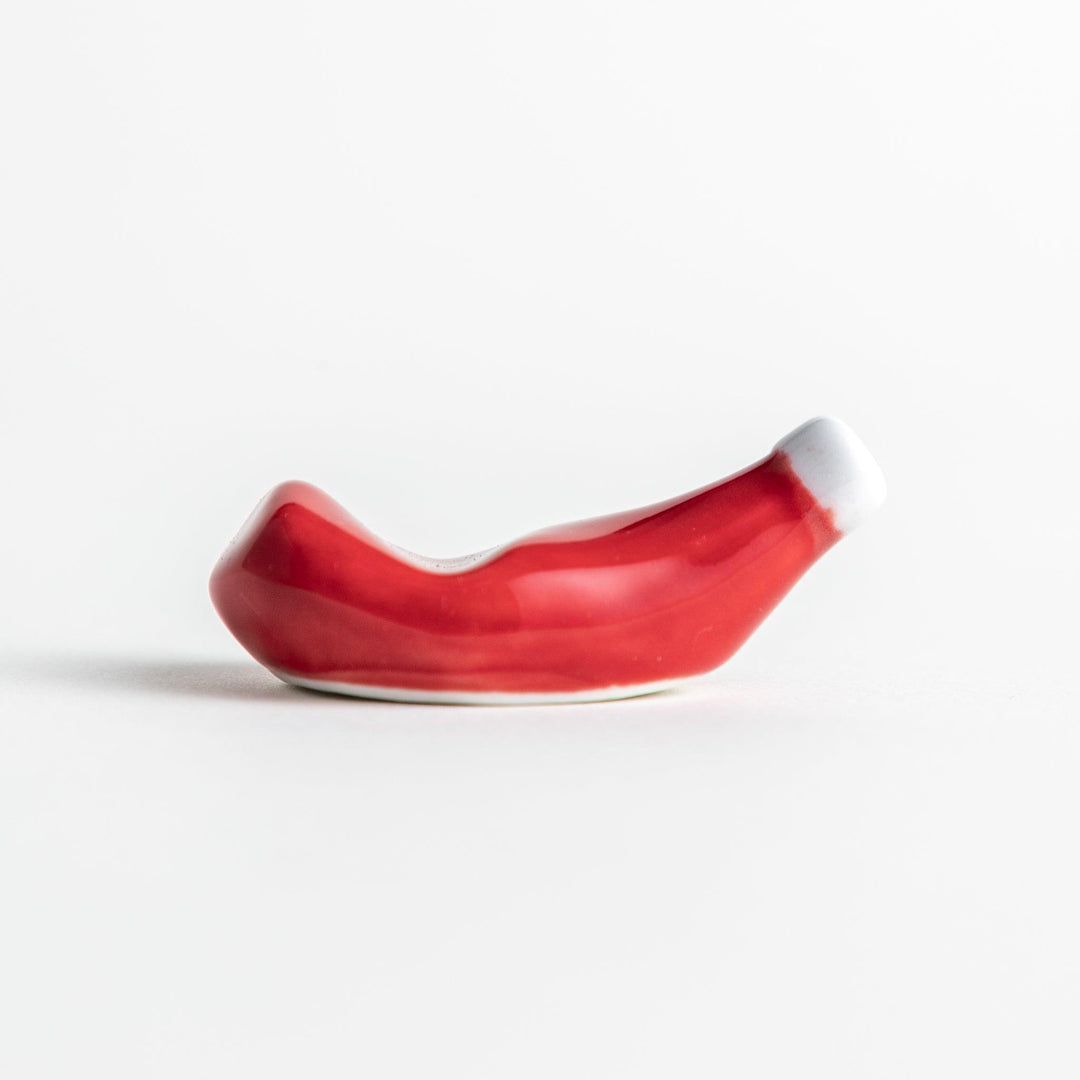 A ceramic chopstick rest resembling a ketchup bottle.