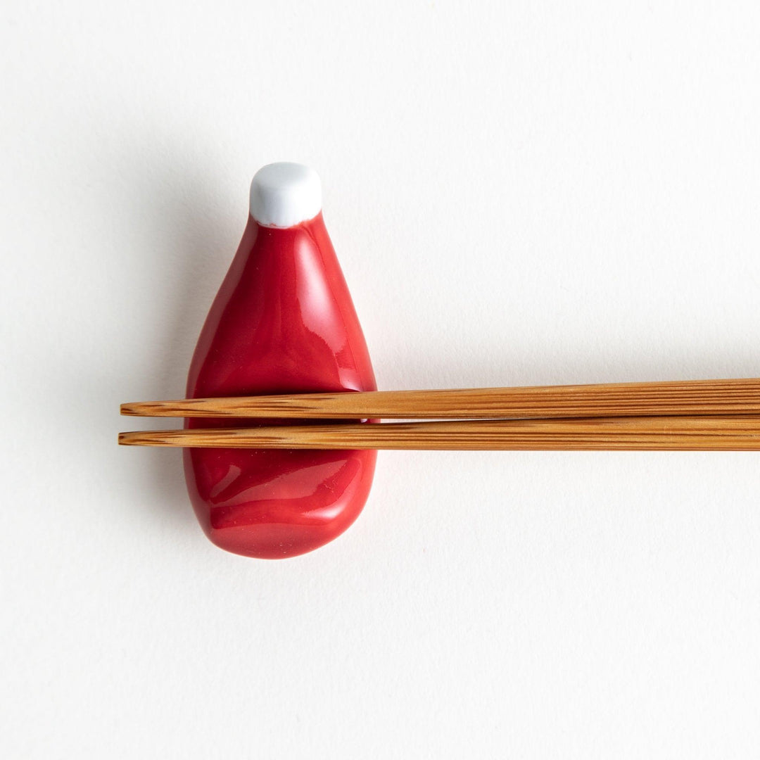 A ceramic chopstick rest resembling a ketchup bottle.