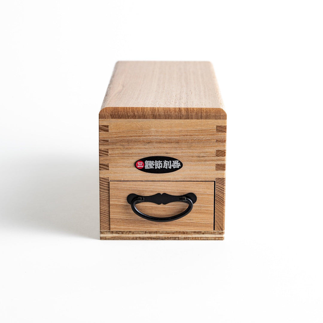 A large wooden box with a sliding drawer and lid, designed for shaving katsuobushi (dried bonito), with a colorful packaging box featuring traditional Japanese artwork.