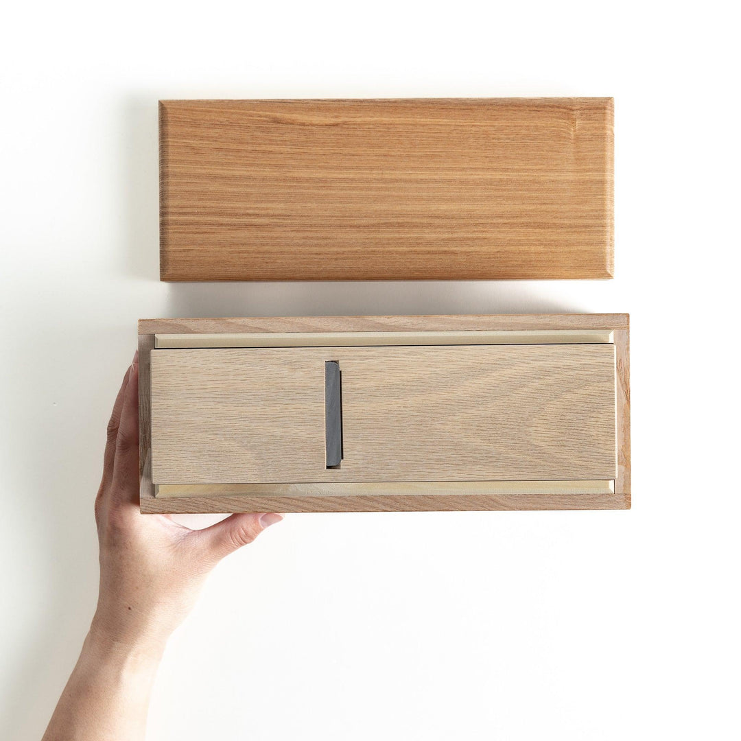 A large wooden box with a sliding drawer and lid, designed for shaving katsuobushi (dried bonito), with a colorful packaging box featuring traditional Japanese artwork.