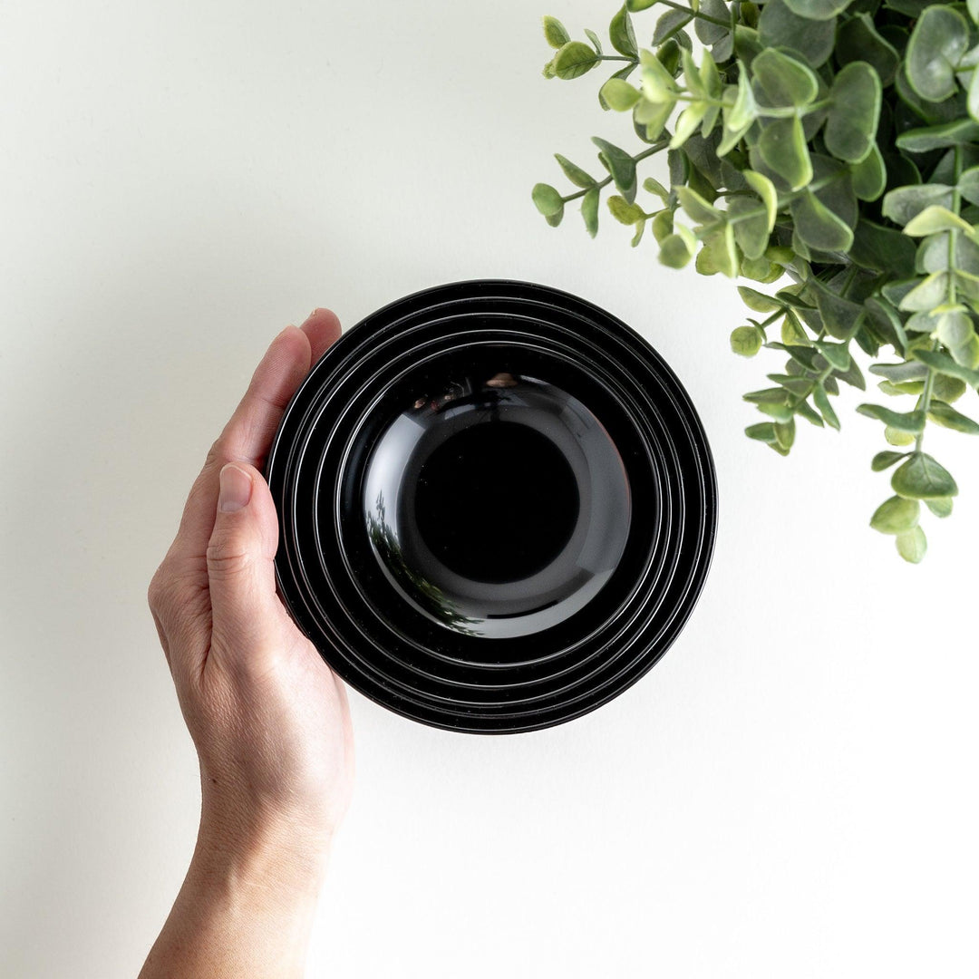 A set of five nested lacquer bowls, each with a footed base, traditionally used in oryoki meals for formal dining settings. Available in black or red.