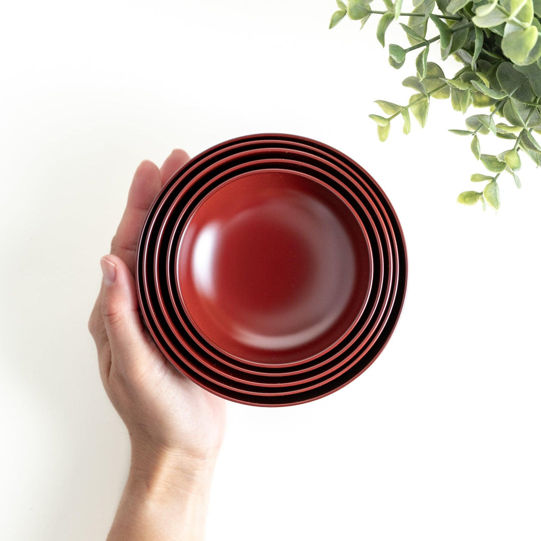 A set of five nested lacquer bowls, each with a footed base, traditionally used in oryoki meals for formal dining settings. Available in black or red.