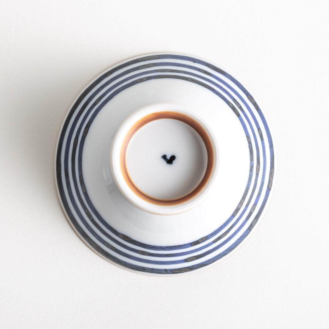 A white ceramic bowl with horizontal blue stripes and a brown rim.