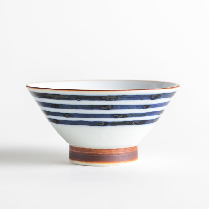 A white ceramic bowl with horizontal blue stripes and a brown rim.