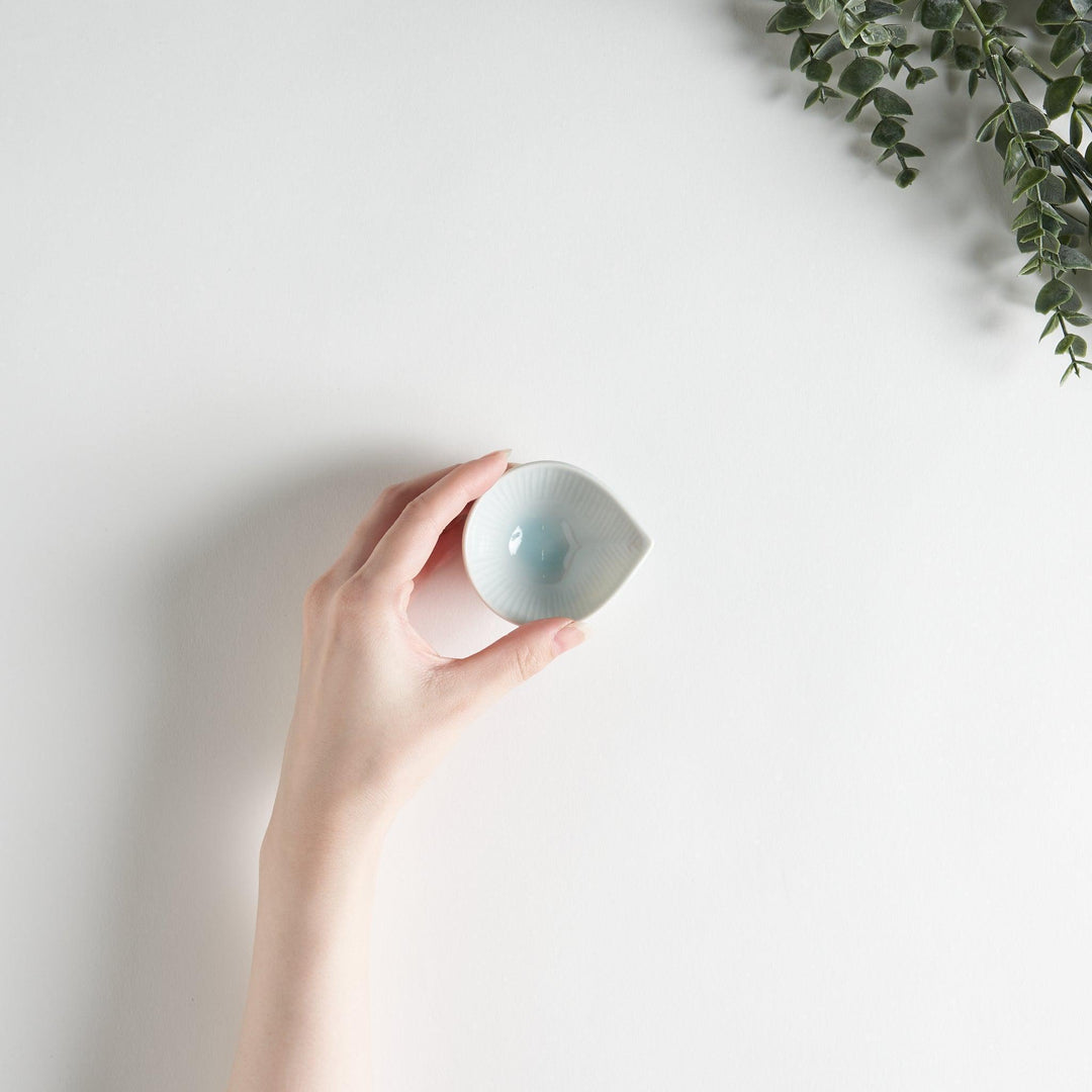 A small white condiment dish with a subtle ribbed pattern.