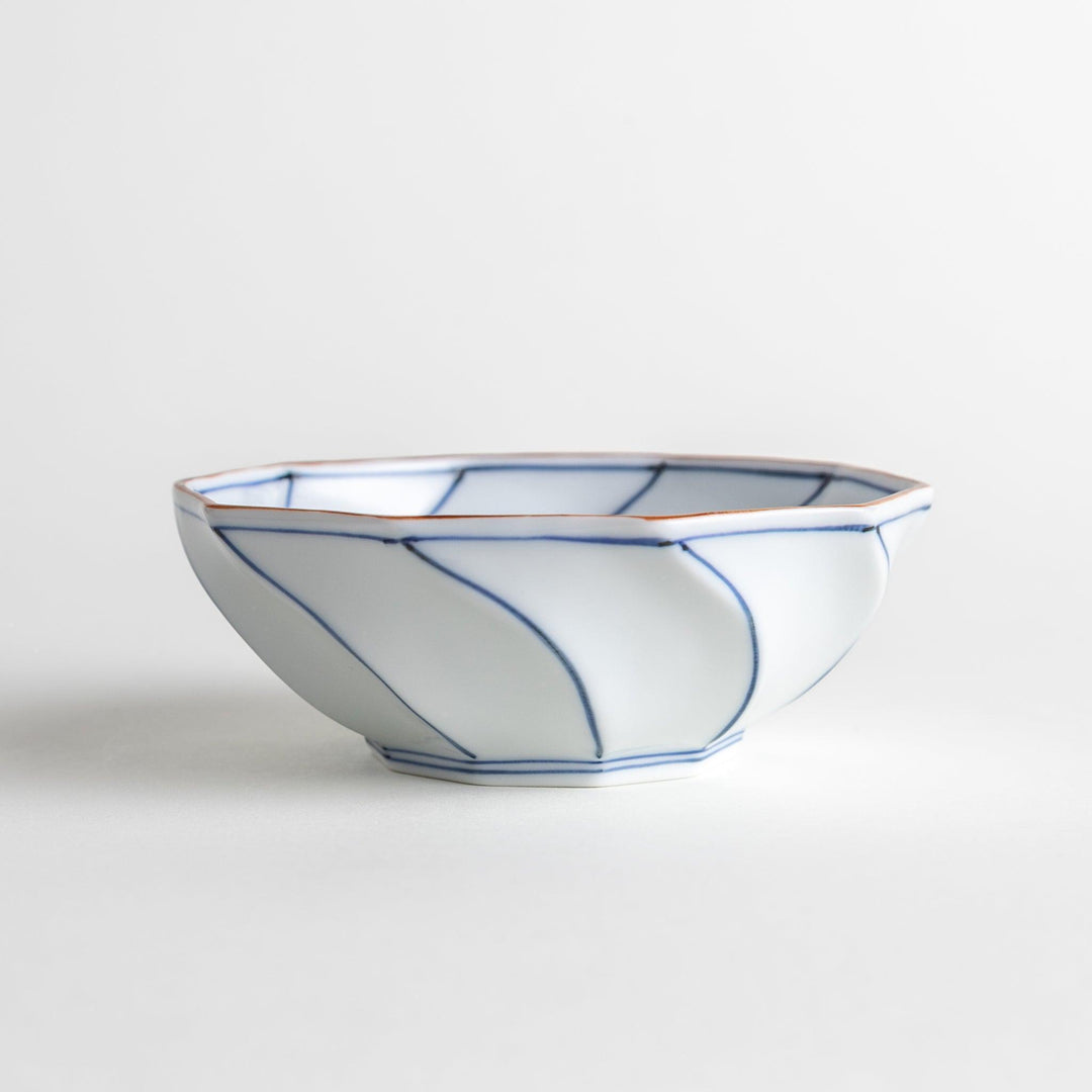 Deep white octagonal dessert bowl with a petal design, outlined in blue or red and finished with a brown rim.