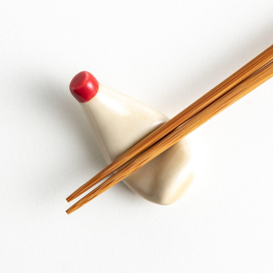 A ceramic chopstick rest resembling a mayonnaise bottle.