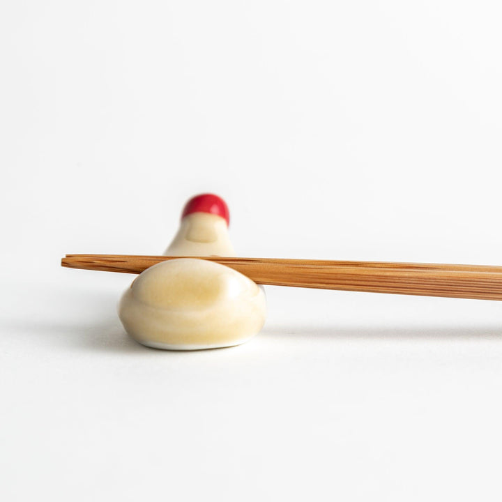 A ceramic chopstick rest resembling a mayonnaise bottle.