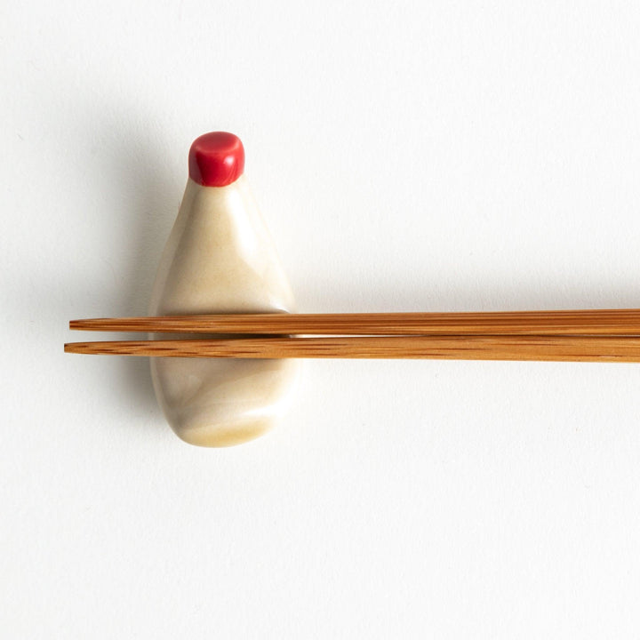 A ceramic chopstick rest resembling a mayonnaise bottle.