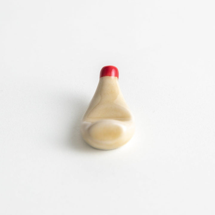 A ceramic chopstick rest resembling a mayonnaise bottle.