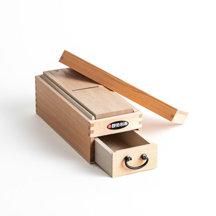 A medium-sized wooden box with a sliding drawer and lid, designed for shaving katsuobushi (dried bonito), with a colorful packaging box featuring traditional Japanese artwork.