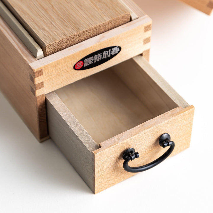 A medium-sized wooden box with a sliding drawer and lid, designed for shaving katsuobushi (dried bonito), with a colorful packaging box featuring traditional Japanese artwork.