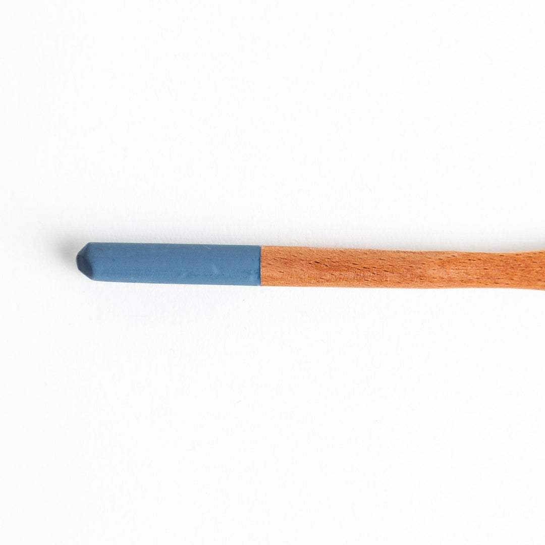 A set of four wooden spatulas with flat tips, each featuring a different colored end—white, black, blue, and red