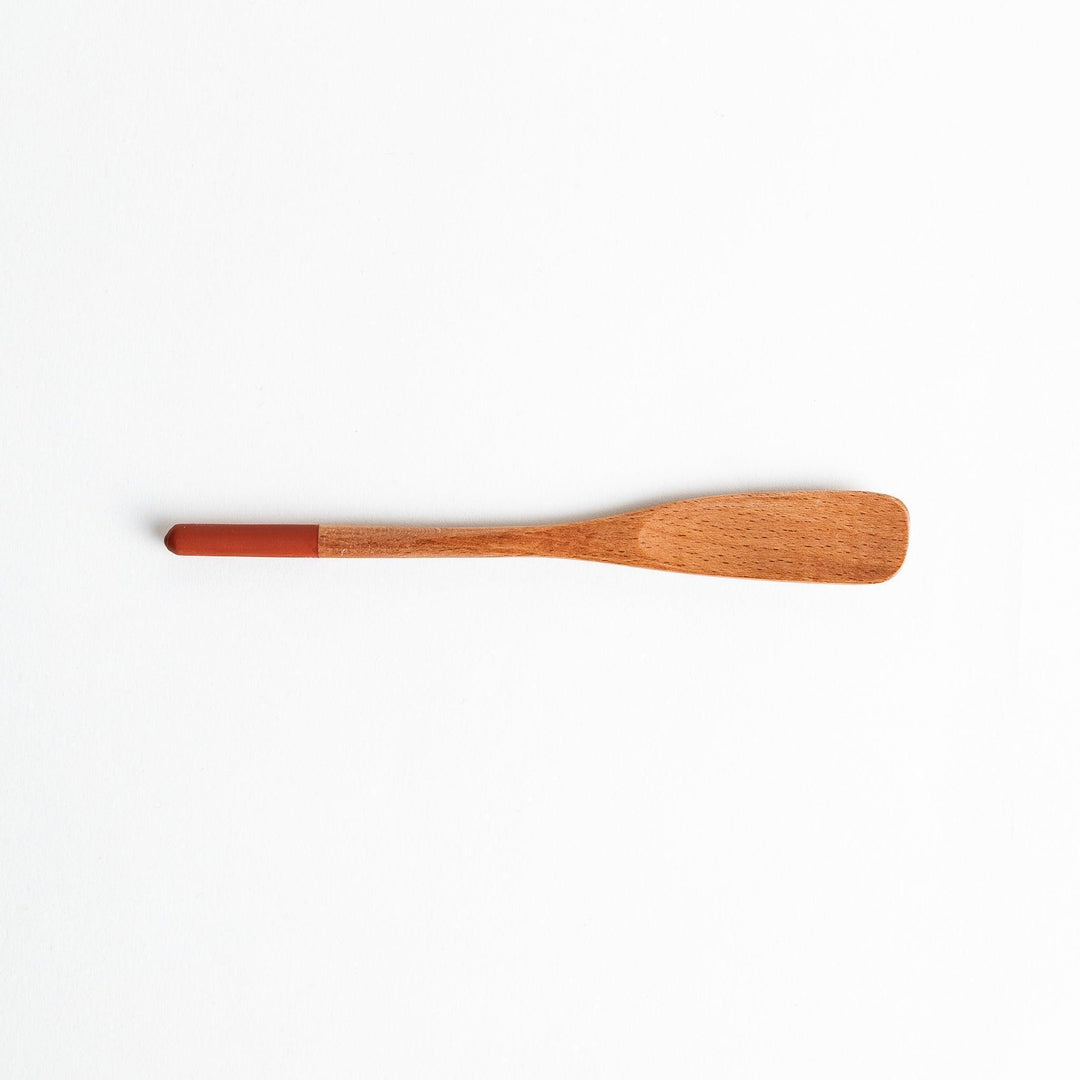 A set of four wooden spatulas with flat tips, each featuring a different colored end—white, black, blue, and red