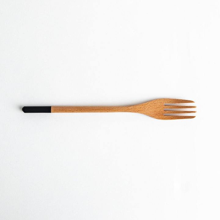 A set of four wooden pasta fork, each with a different colored tip—white, black, blue, and red.