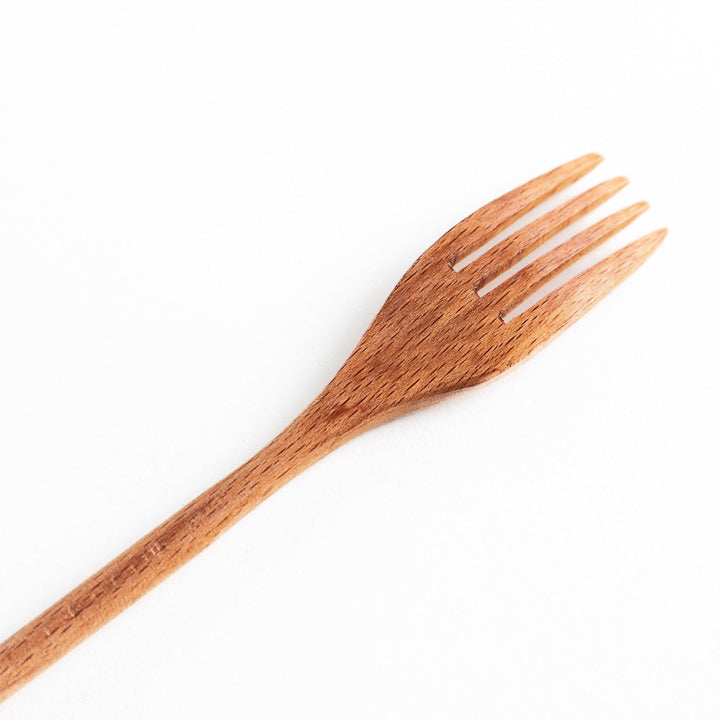 A set of four wooden pasta fork, each with a different colored tip—white, black, blue, and red.