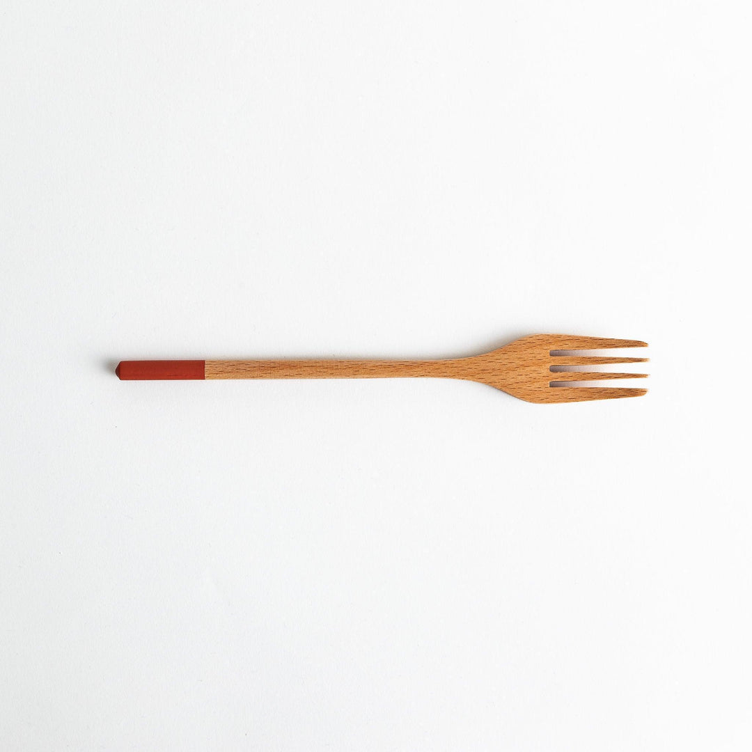 A set of four wooden pasta fork, each with a different colored tip—white, black, blue, and red.