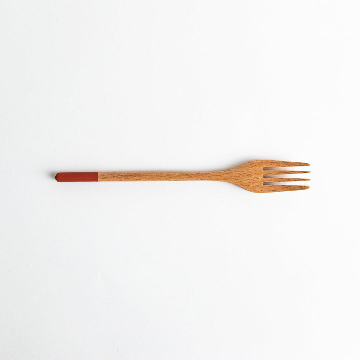 A set of four wooden pasta fork, each with a different colored tip—white, black, blue, and red.