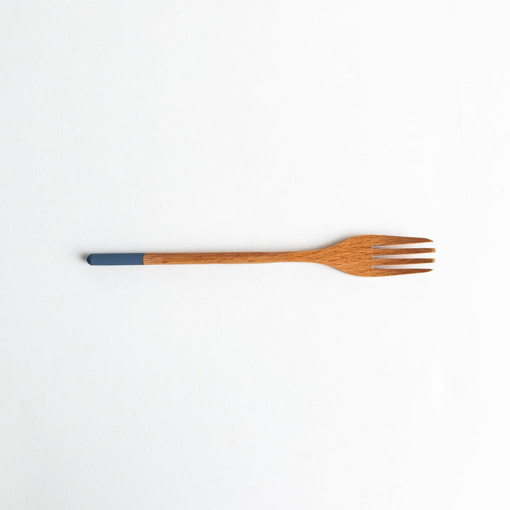 A set of four wooden pasta fork, each with a different colored tip—white, black, blue, and red.