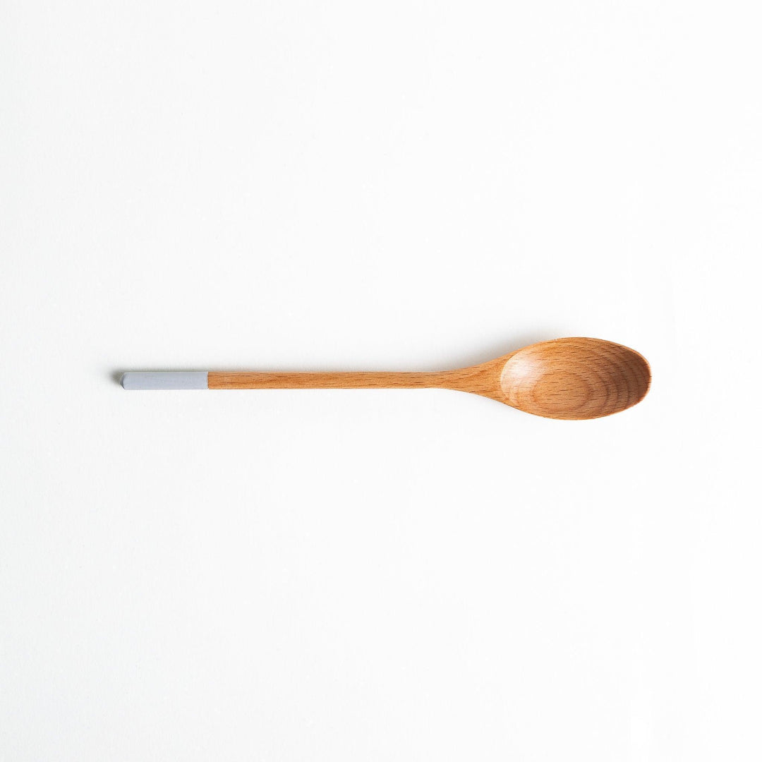 A set of four wooden curry spoons, each with a different colored tip—white, black, blue, and red.