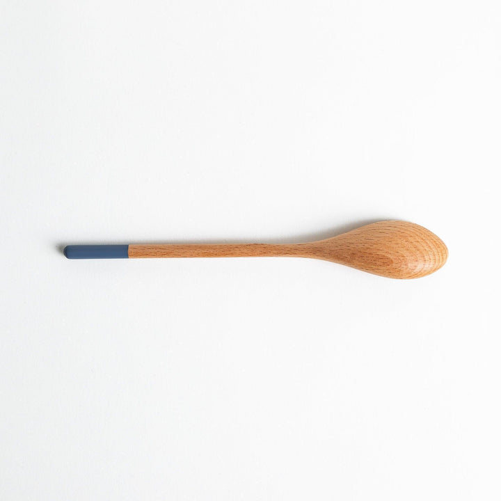 A set of four wooden curry spoons, each with a different colored tip—white, black, blue, and red.