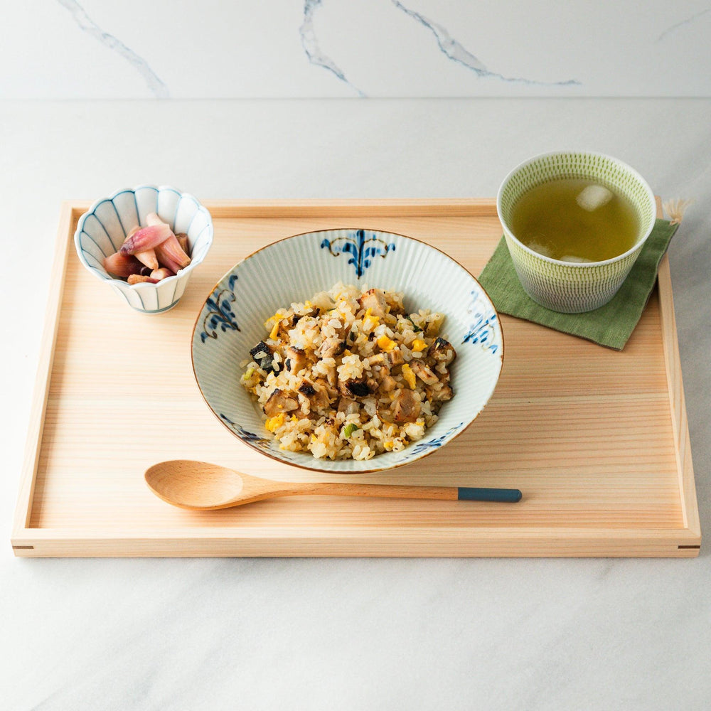 A set of four wooden curry spoons, each with a different colored tip—white, black, blue, and red.