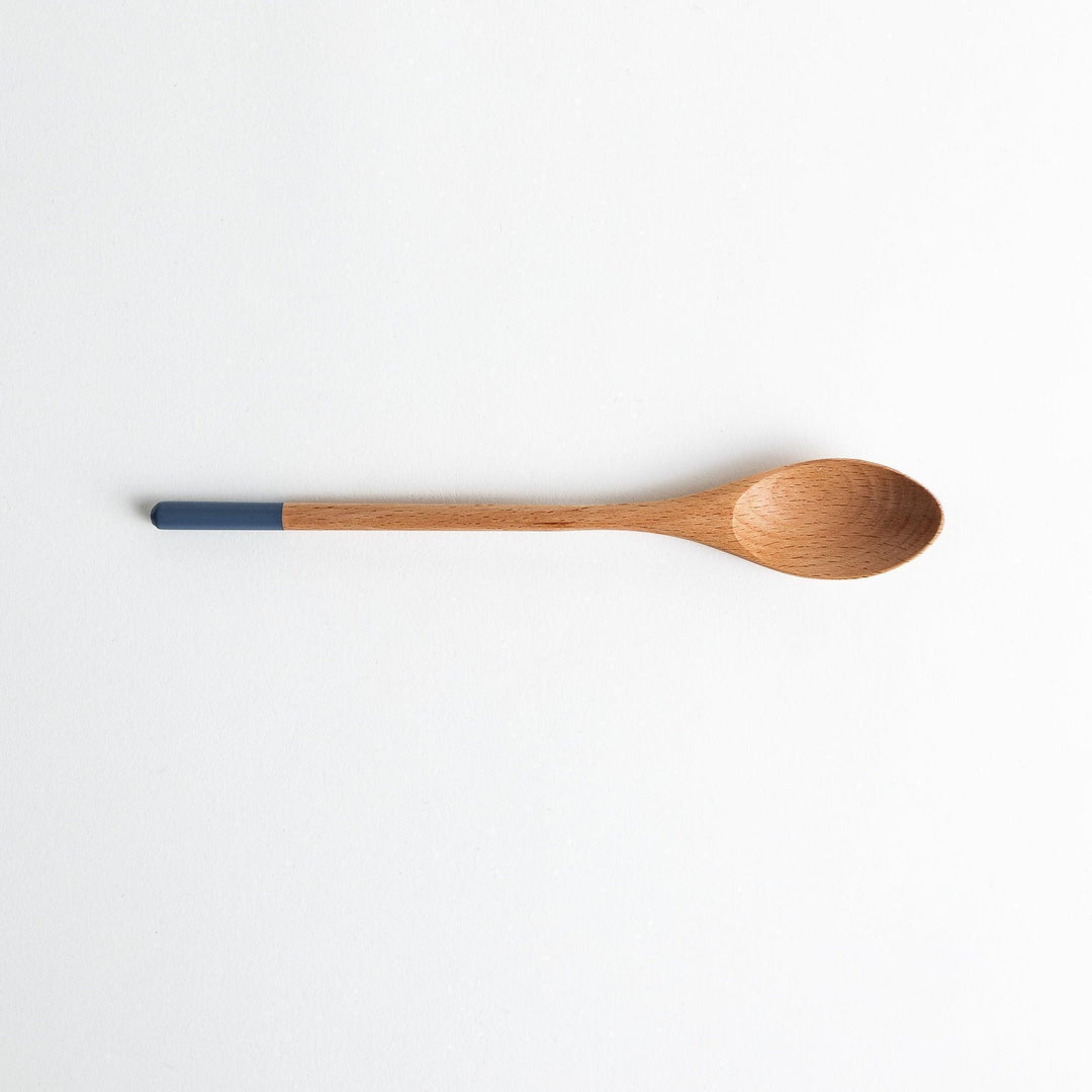 A set of four wooden curry spoons, each with a different colored tip—white, black, blue, and red.