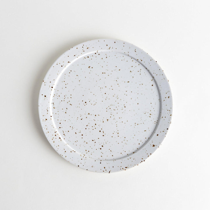 Round ceramic dinner plates, one in dark gray and the other in speckled white.