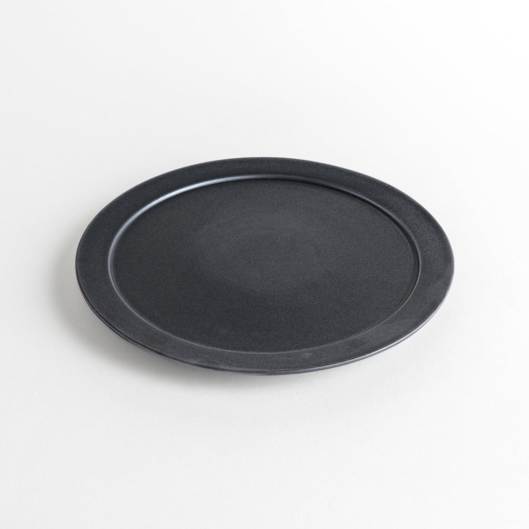 Round ceramic dinner plates, one in dark gray and the other in speckled white.