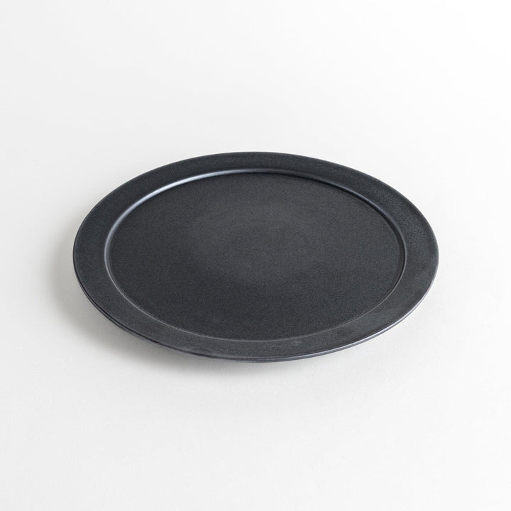 Round ceramic dinner plates, one in dark gray and the other in speckled white.