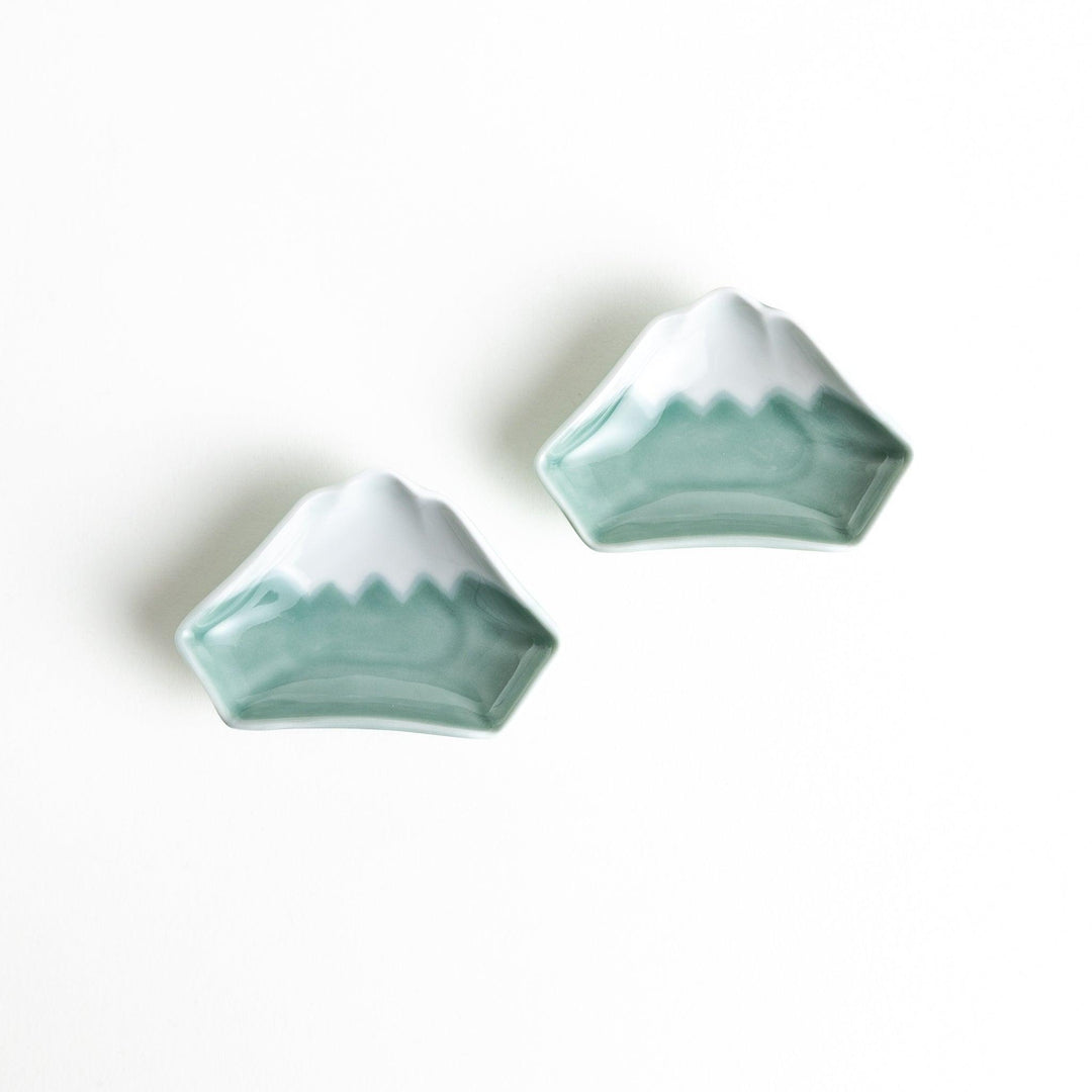 A small ceramic dish shaped like Mount Fuji with green and white colors.