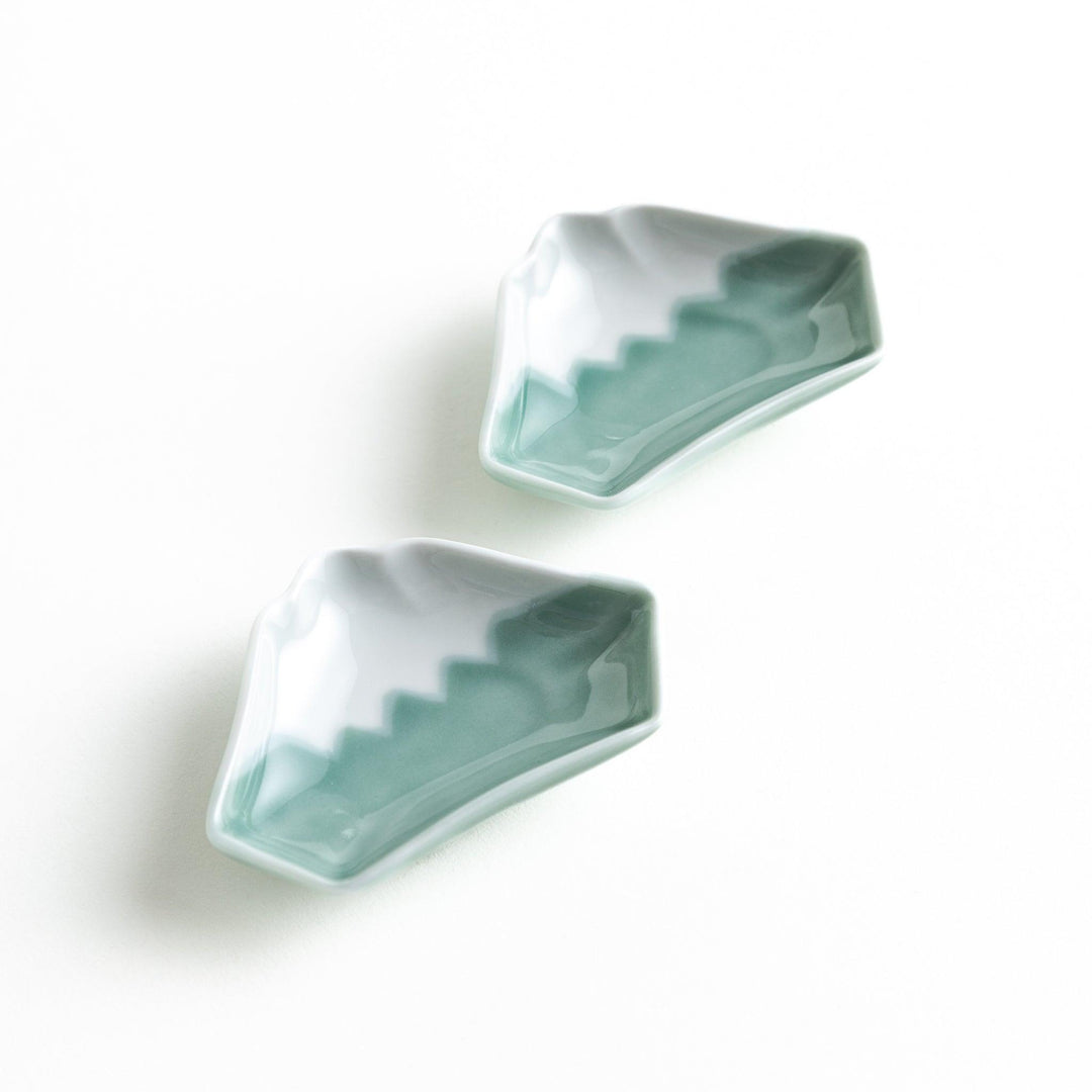 A small ceramic dish shaped like Mount Fuji with green and white colors.