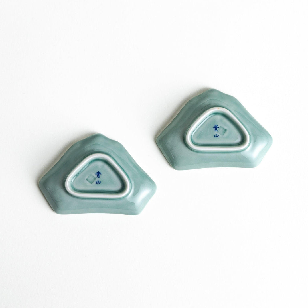 A small ceramic dish shaped like Mount Fuji with green and white colors.