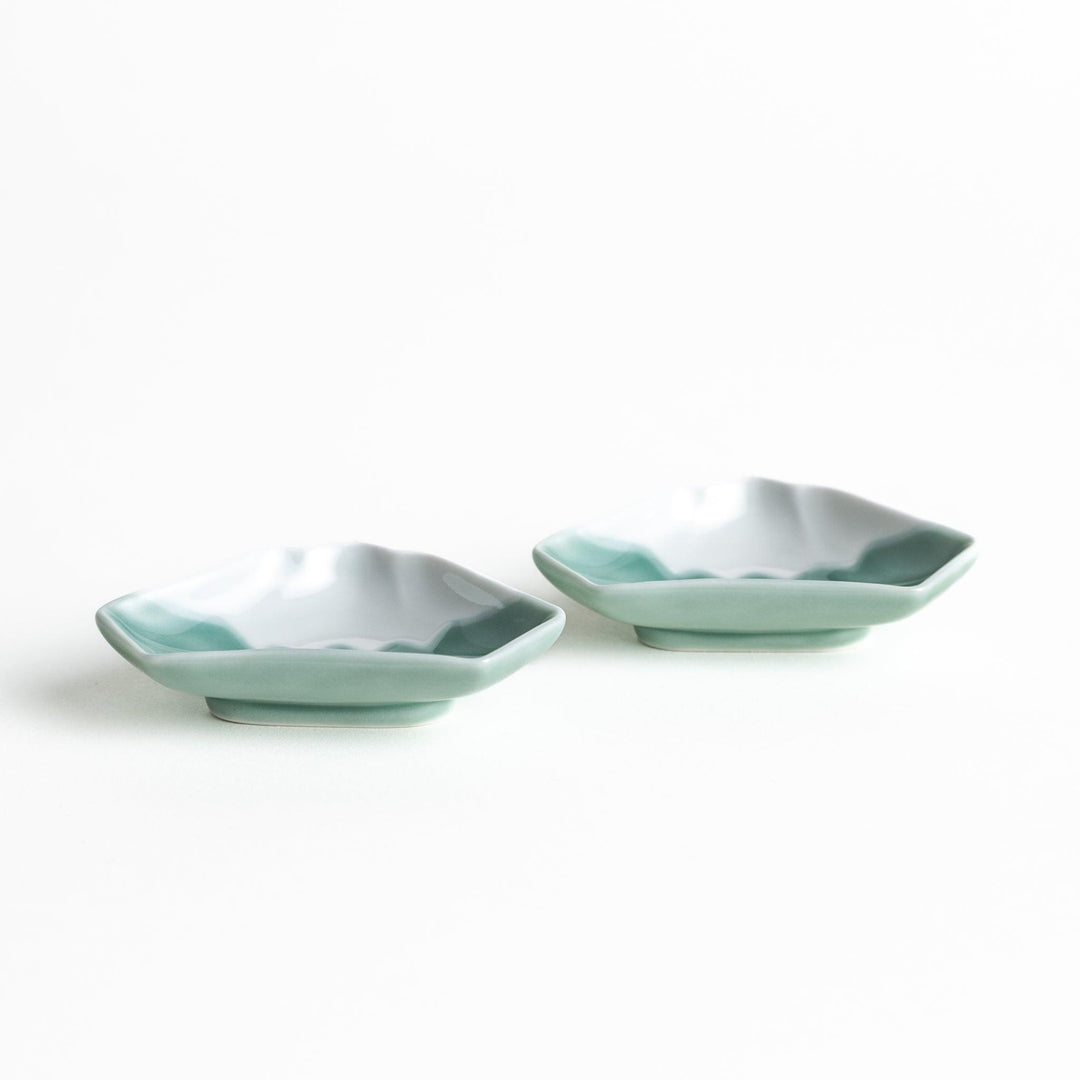 A small ceramic dish shaped like Mount Fuji with green and white colors.