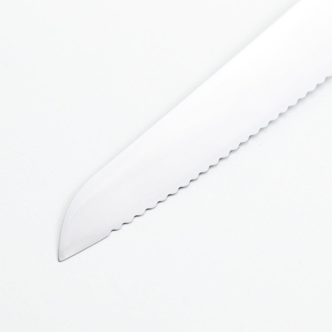 Nagomi bread knife with a serrated stainless steel blade and a polished wooden handle, displayed on a white background.