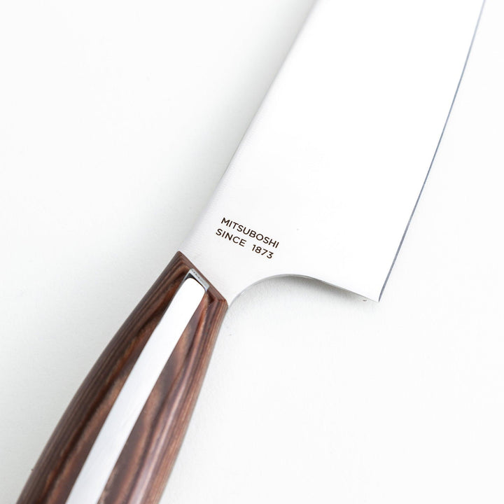 Nagomi chef's knife featuring a stainless steel blade and a sleek wooden handle, displayed on a white background.