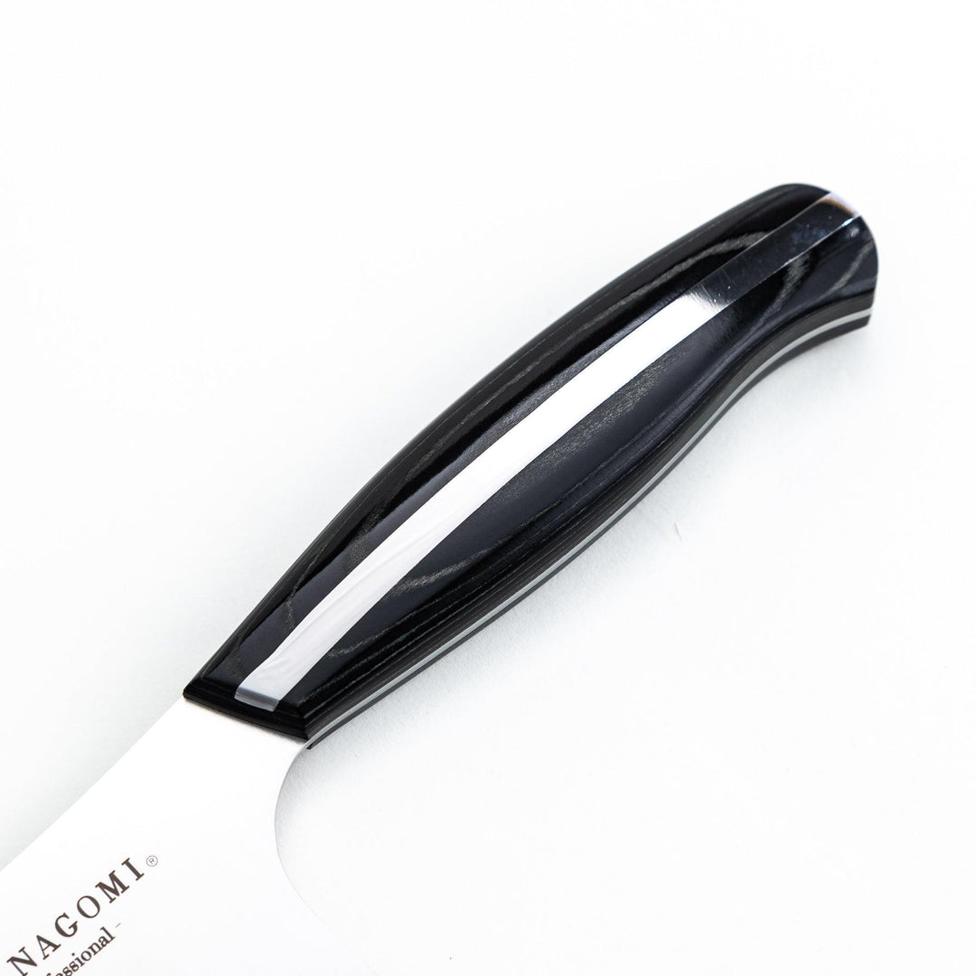 Nagomi professional chef's knife with a stainless steel blade and a black and silver handle, displayed on a dark textured background.