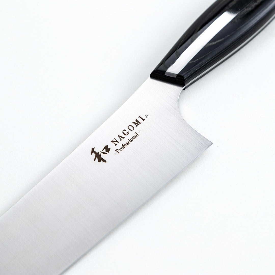 Nagomi professional chef's knife with a stainless steel blade and a black and silver handle, displayed on a dark textured background.