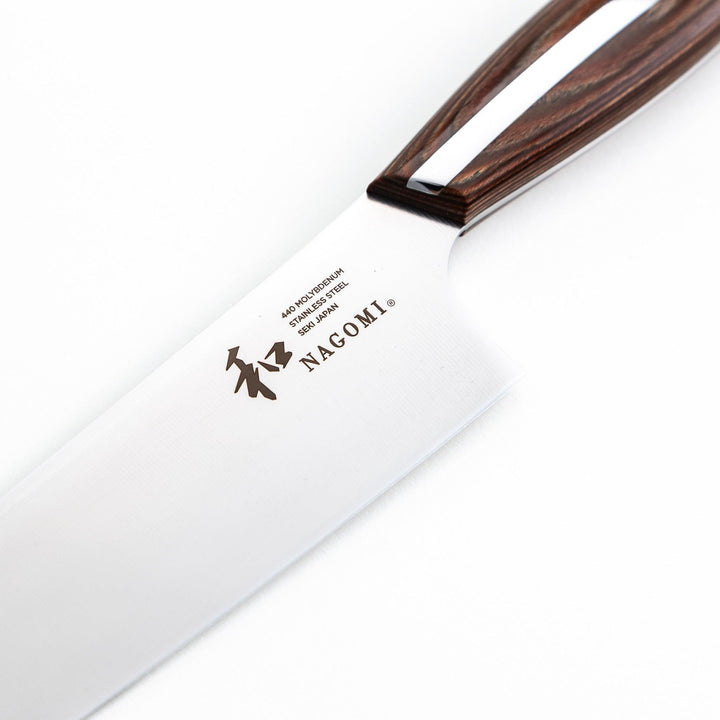 Nagomi Santoku knife with a sharp stainless steel blade and a polished wooden handle, displayed on a white background.